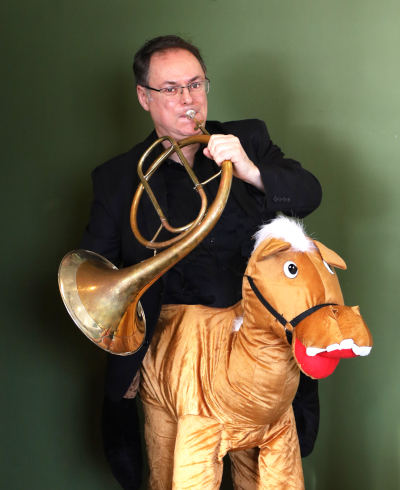 Ken MacDonald with a horn riding a costume horse