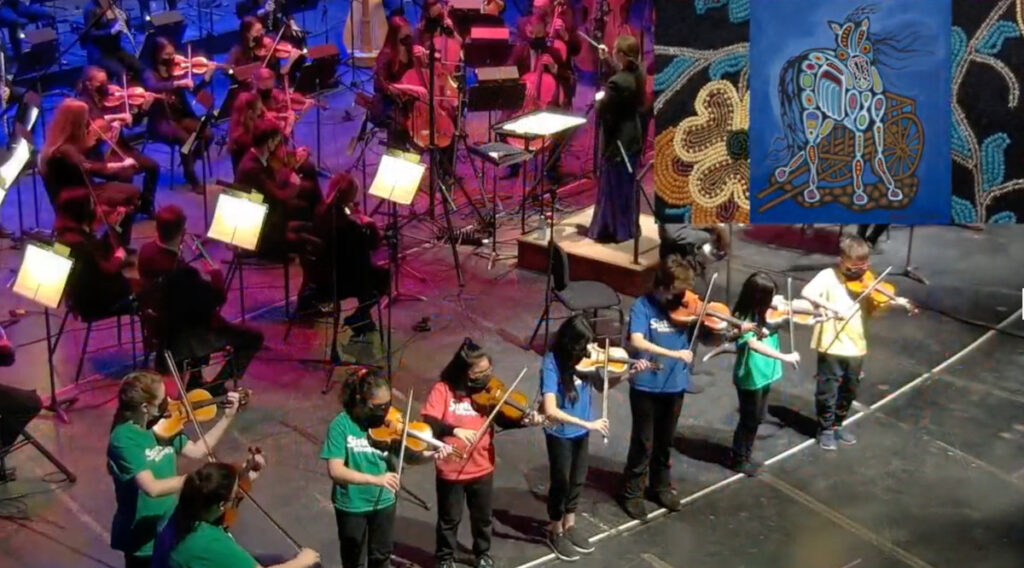 Young musicians of the Winnipeg Symphony Orchestra Sistema Program play along with the WSO at the premiere of "The Spirit Horse Returns" in March 2022. 
